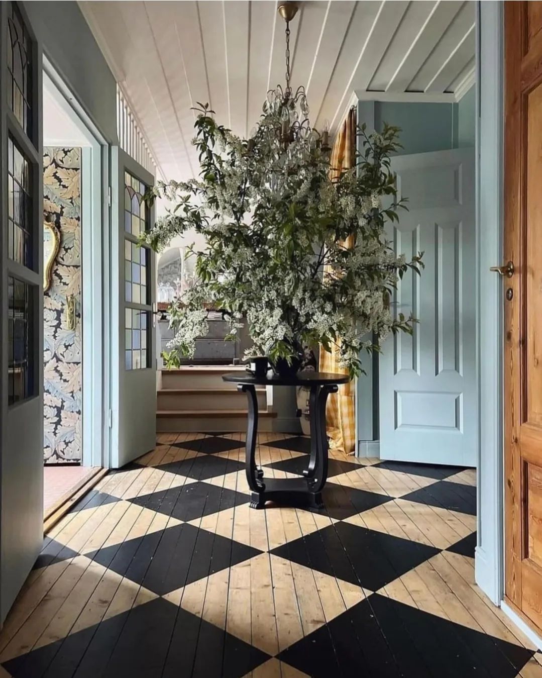 A chic hallway with a contrasting black and white checkerboard floor