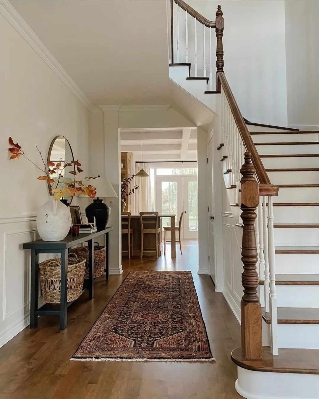 A tastefully designed hallway with a wooden staircase and decorative elements