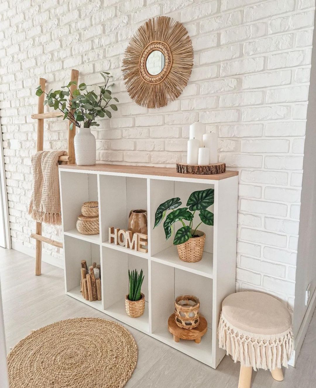 A modern and cozy interior featuring white shelving units adorned with various decorative items, such as plants, candles, and wooden accents.