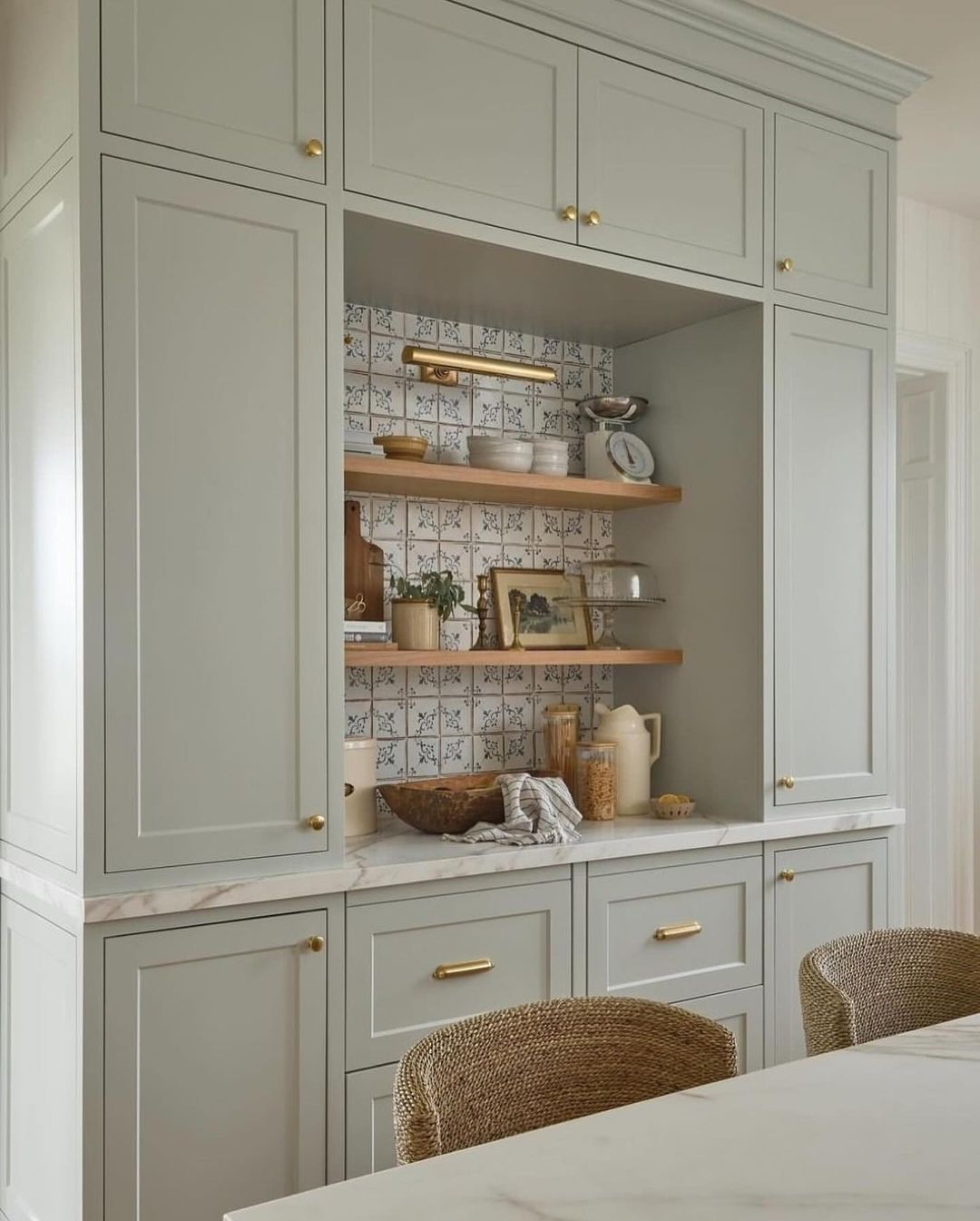 Stylish grey kitchen cabinetry with open shelving accented by patterned backsplash