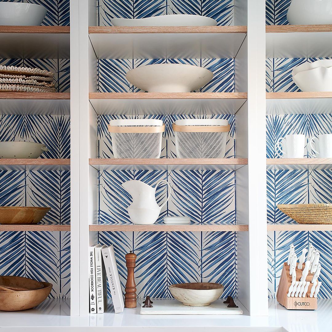 Beautifully organized open shelving in a kitchen with patterned backsplash