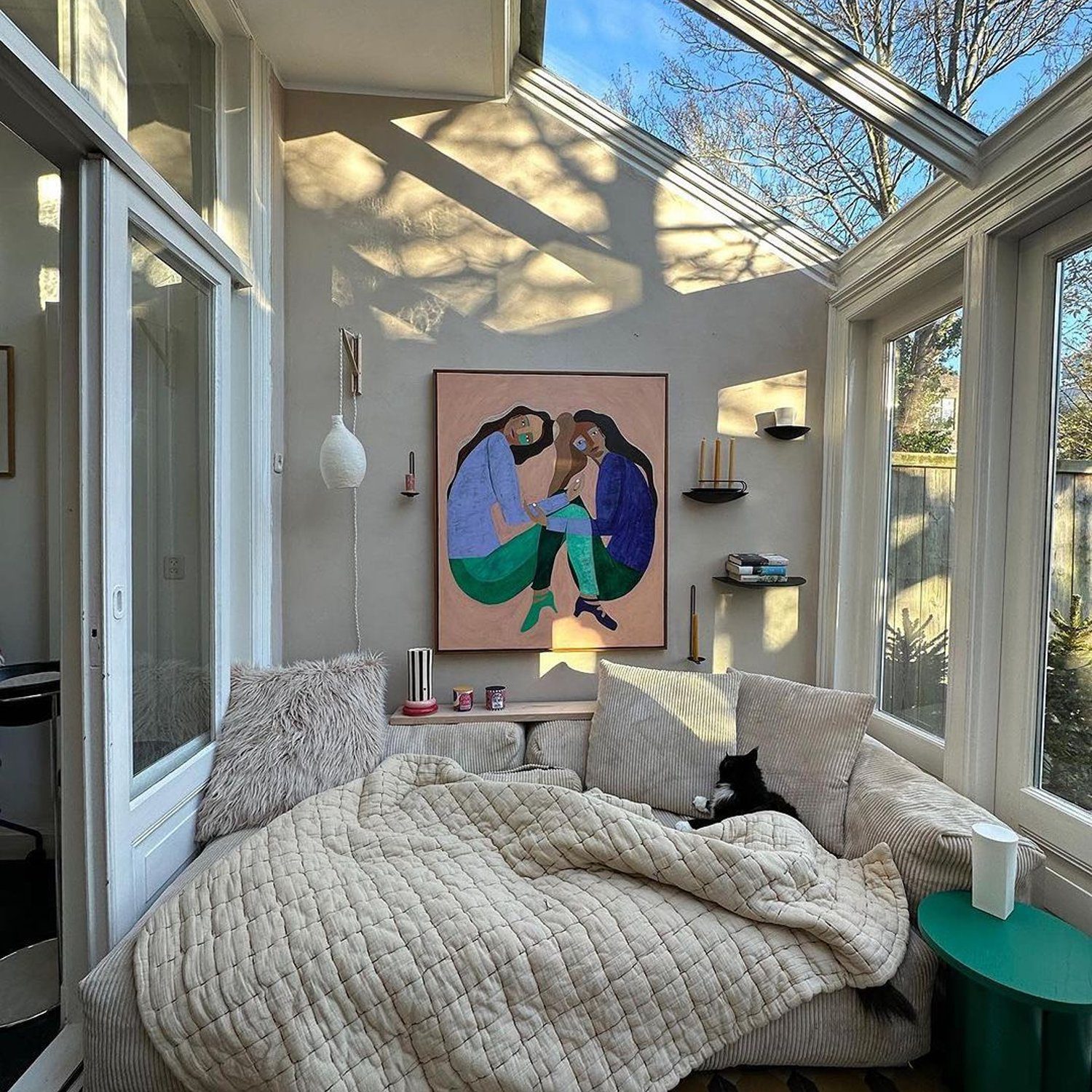 Cozy sunlit room with skylight and large artwork