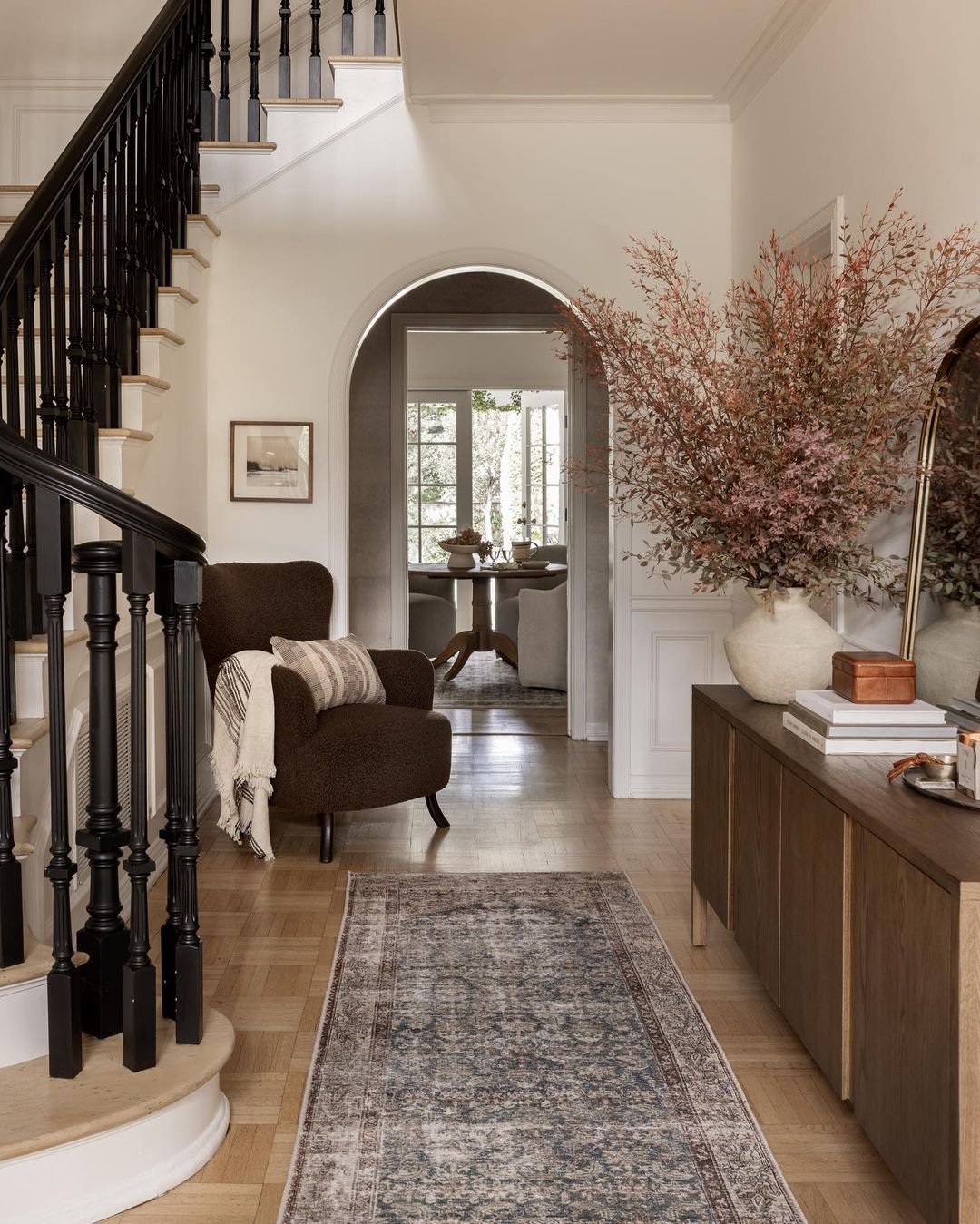 A tastefully designed entryway with contrasting black and natural wood elements