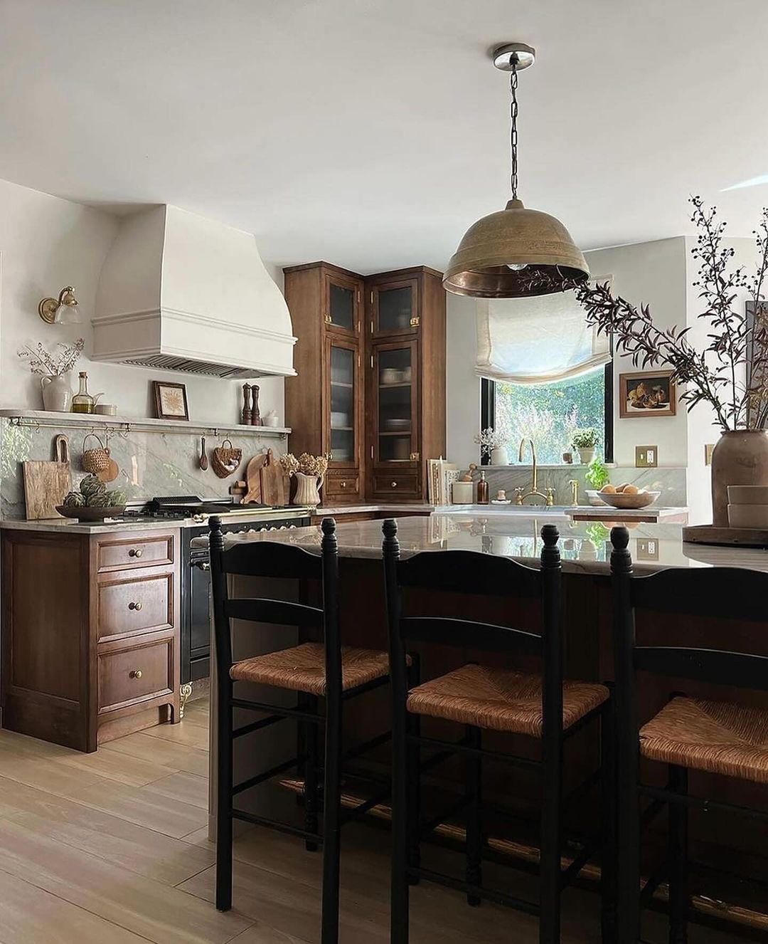 A tastefully designed kitchen featuring rich wooden cabinetry and a central island with woven bar stools.