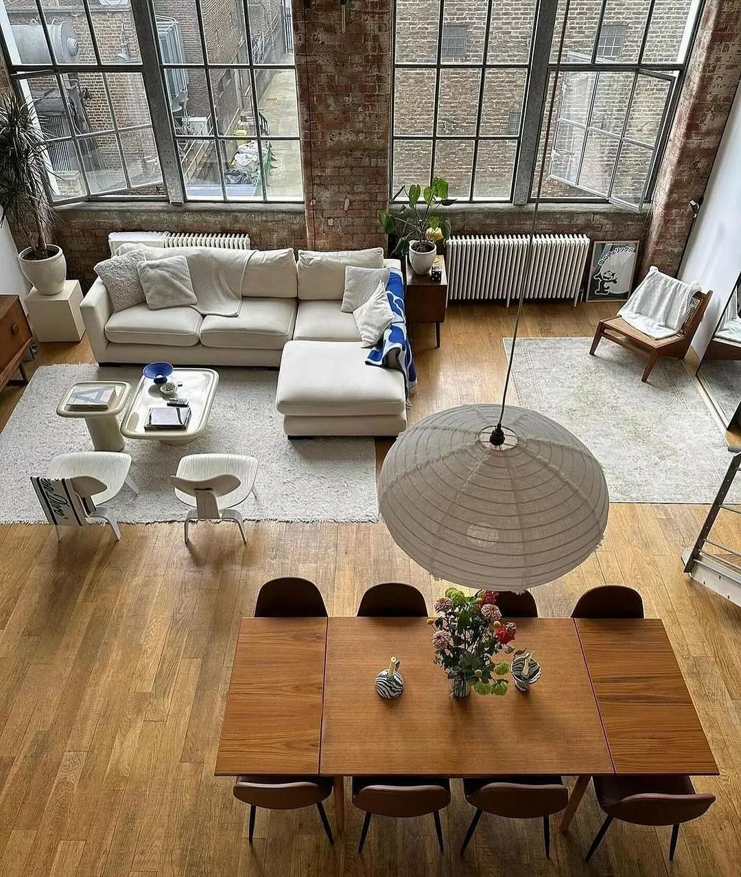 A chic urban loft living space with expansive windows and exposed brick walls