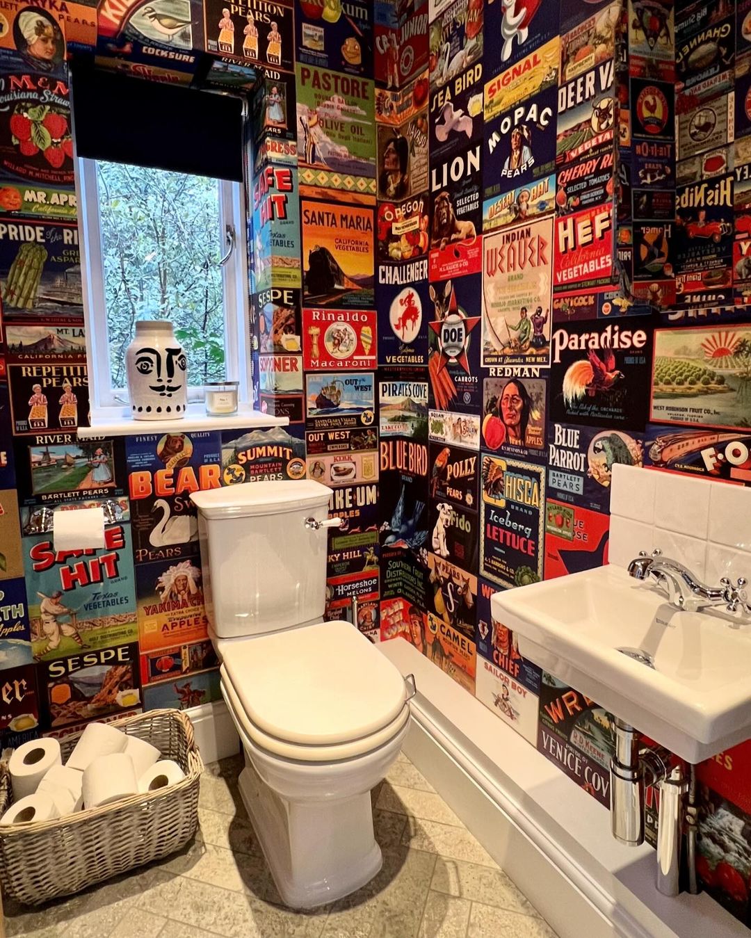 A unique bathroom design featuring a vibrant display of vintage fruit crate labels as wallpaper