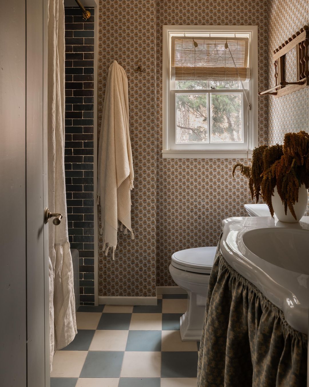 A cozy, vintage-style bathroom with patterned tiles and natural light