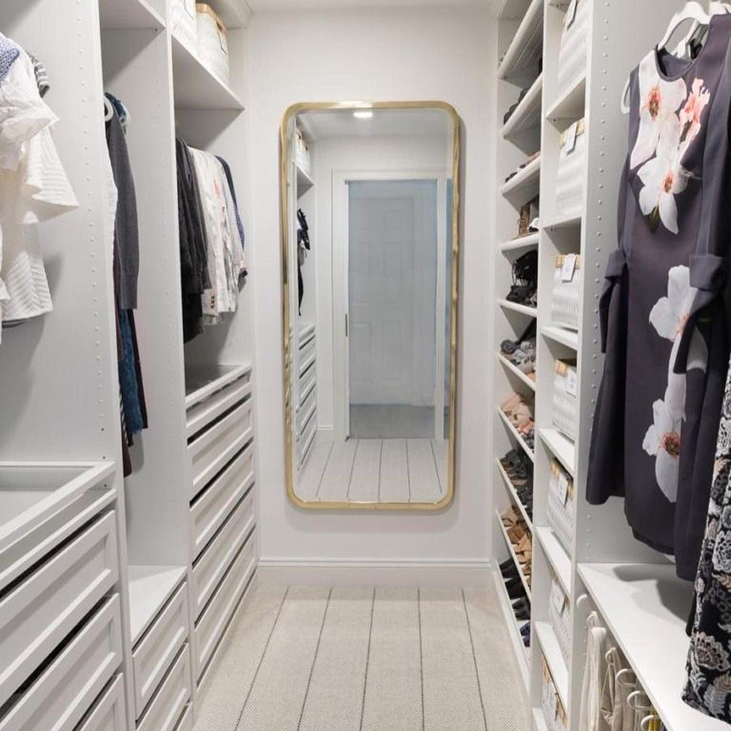 Elegantly designed walk-in closet with ample shelving and a large mirror