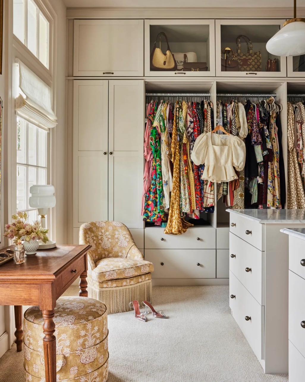 A well-organized walk-in closet with an array of colorful dresses and stylish bags on display