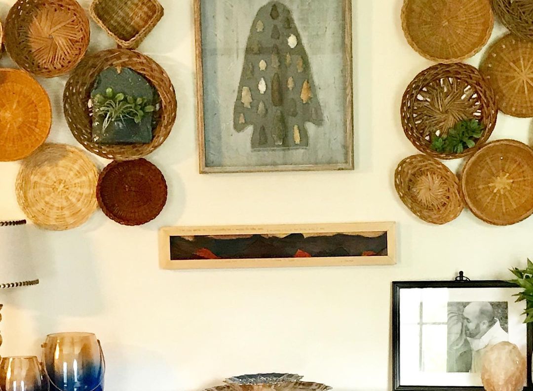 A tastefully arranged wall decor with baskets and artwork