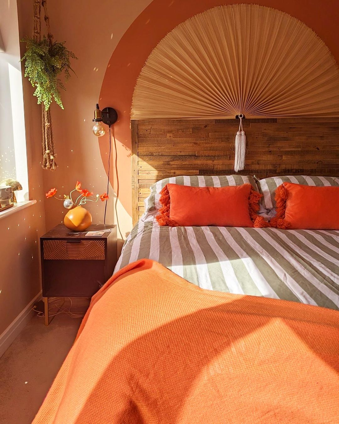 A cozy bedroom with warm orange tones and artistic decor