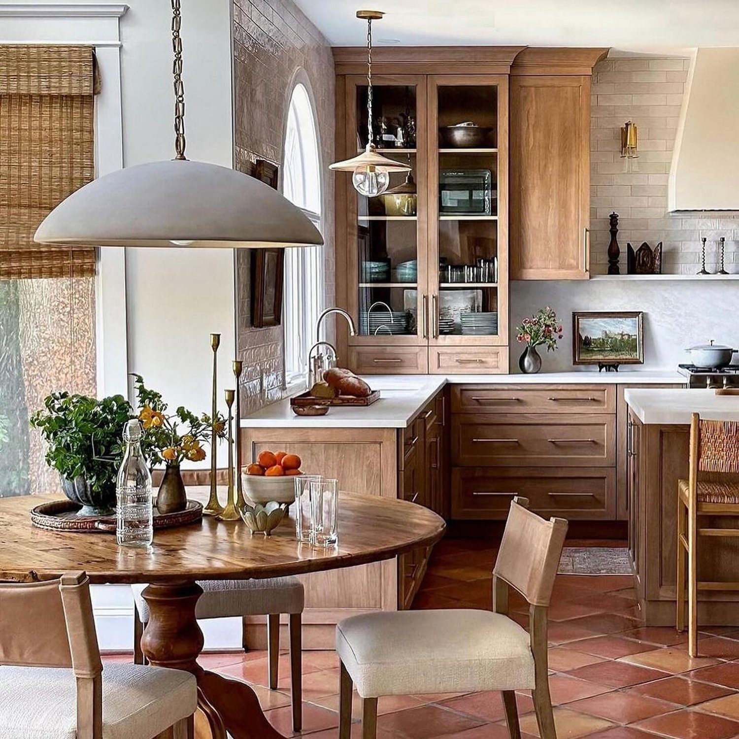 A harmonious kitchen combining rustic wood elements with terracotta floors and a touch of modernity.