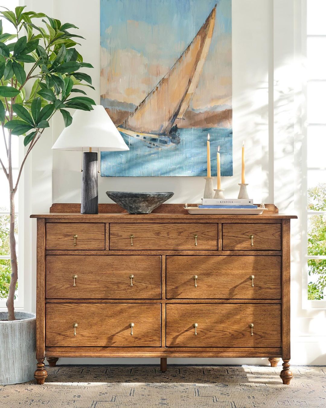 A well-appointed bedroom dresser with sailing artwork